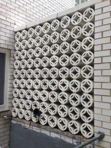 Two sided separation wall--stacked terra cotta pieces meant to draw the eye