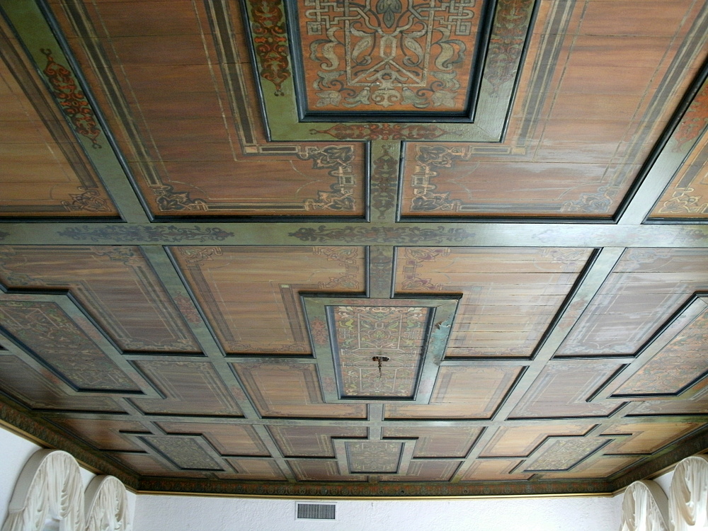 Hand-stenciled ceiling in muted green and red tones
